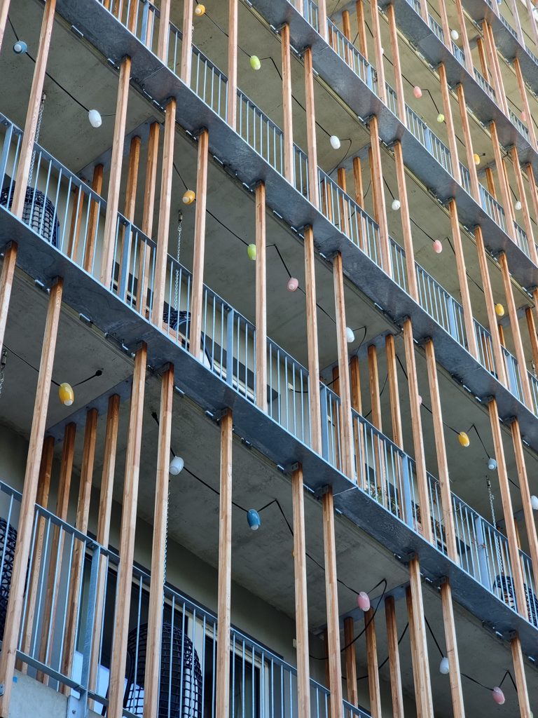 A residential building with exterior patios, aesthetically designed with simple materials such as concrete, steel and wood