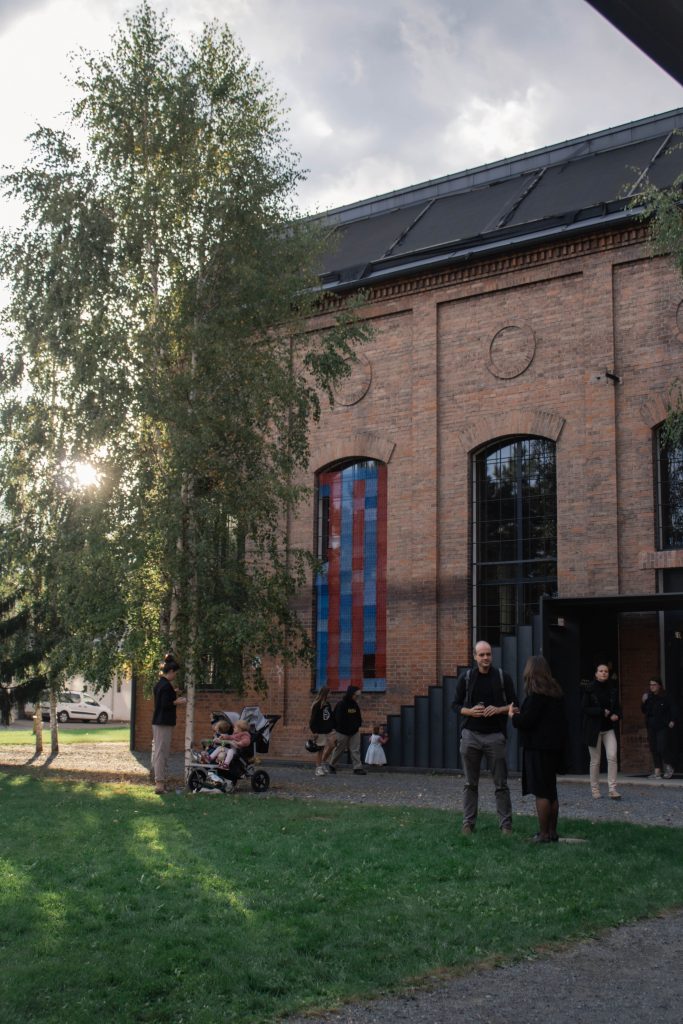 Guests gathering outside of a brick building, where a musical event just ended